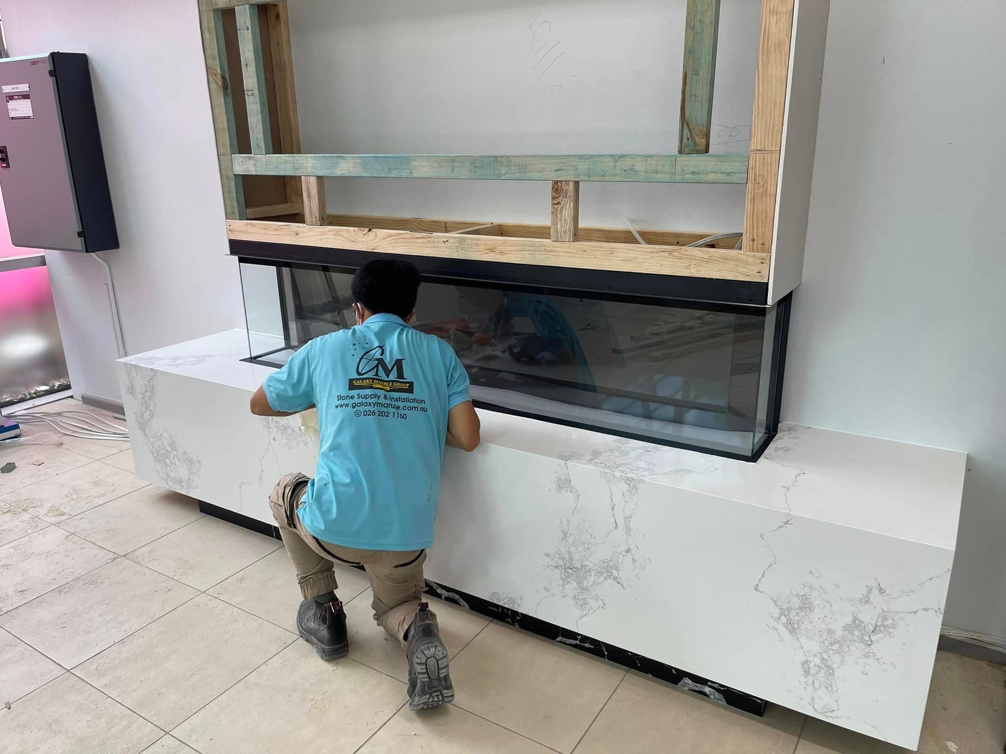 A Galaxy Marble Group installer fitting a stone reception counter on site